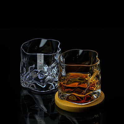 Deux verres Crumple givrés sur table, un tenu en main et un vide, texture froissée visible