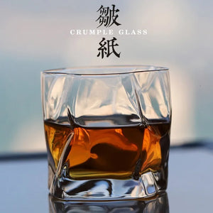 Verre Crumple rempli de whisky, plis irréguliers du cristal visibles en gros plan